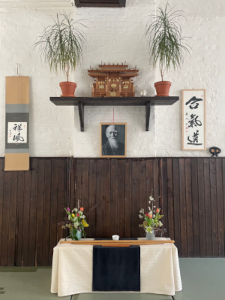 Kaligraphien und kleiner Schrein mit O-Sensei und Blumen